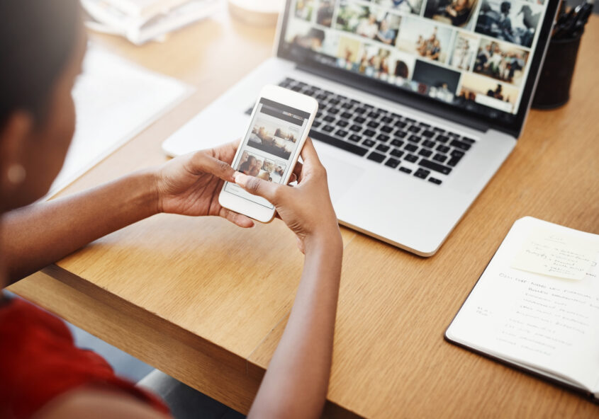 Woman using phone and laptop
